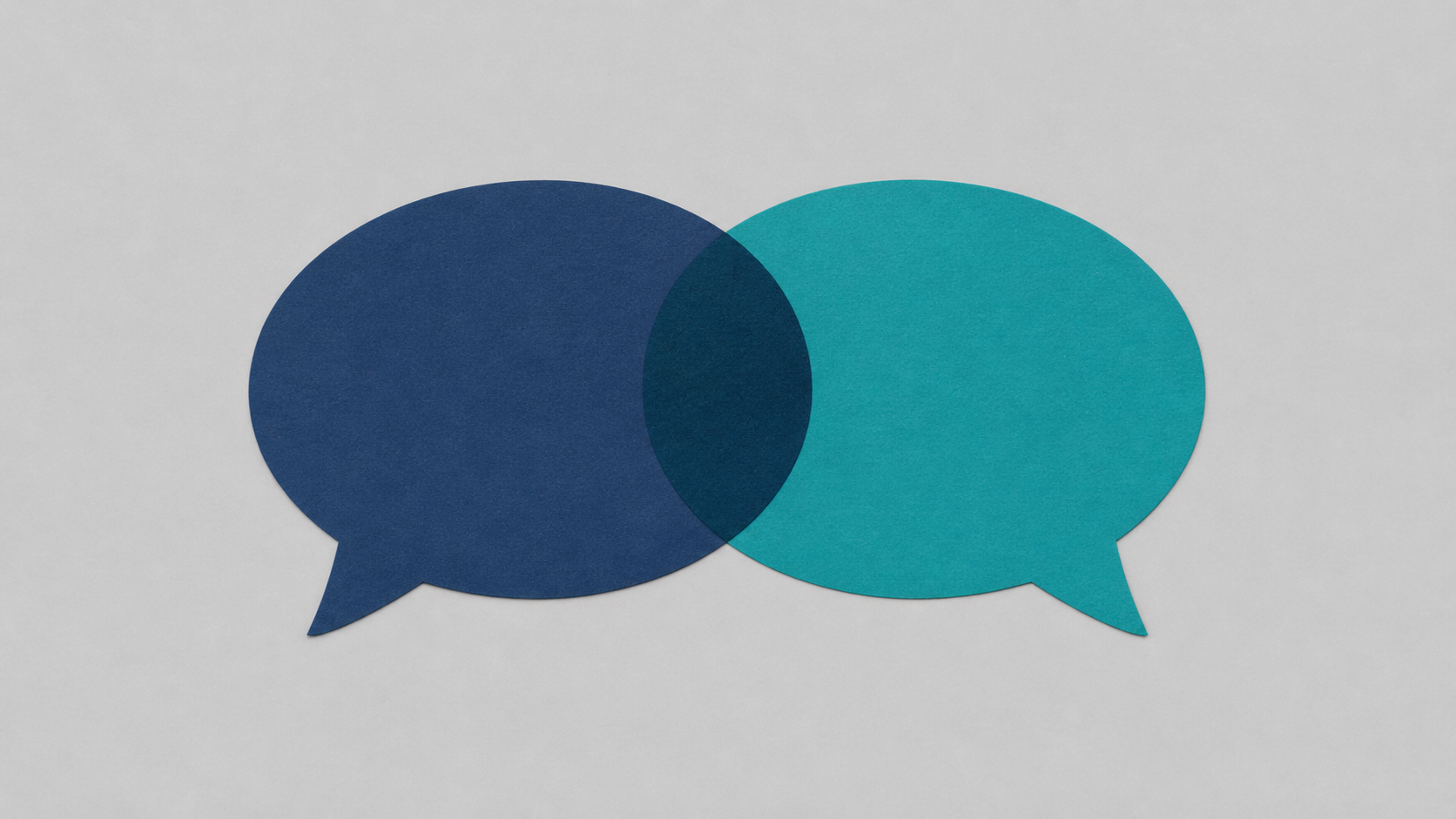 Two overlapping speech bubbles in different colours on a light surface — multilingual AI customer service across languages